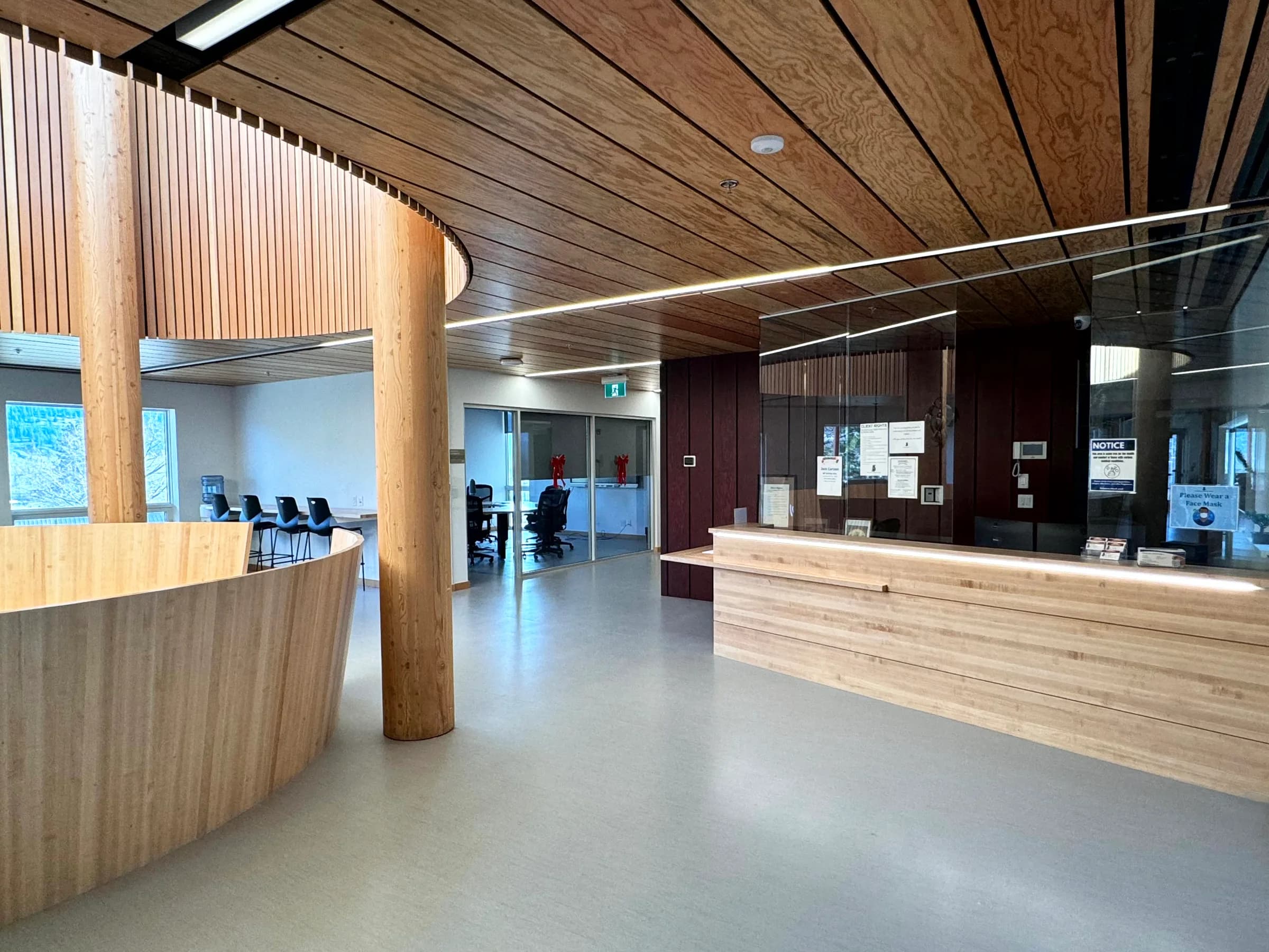 The reception desk in timber, with the curved drum wall behind.