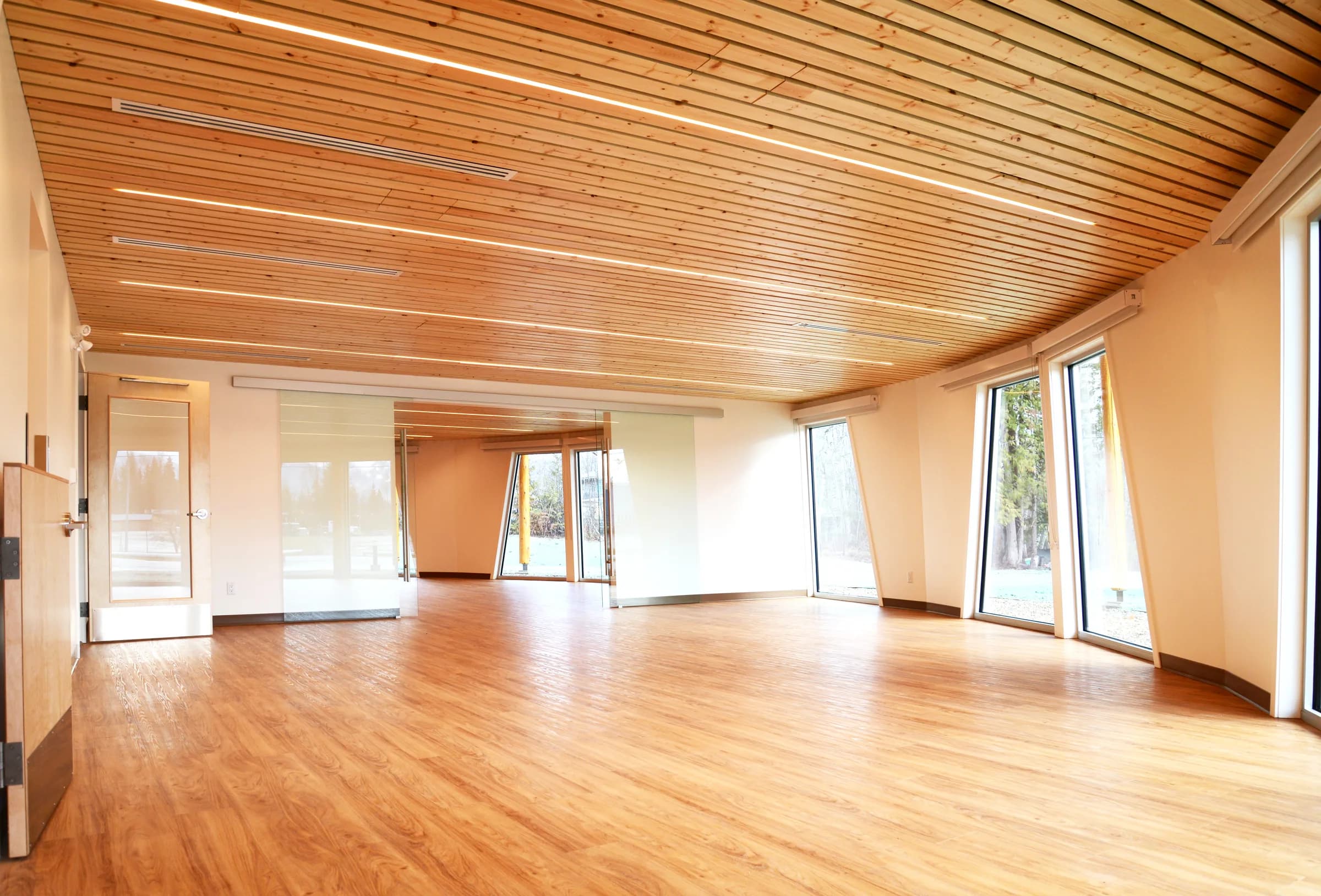 A bright, open play space with a timber ceiling and windows on two sides.