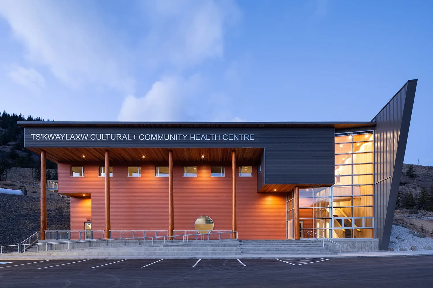 The centre's main elevation in daylight, signage above the entrance and the hillside rising behind.